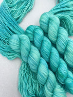 Turquoise yarn skeins on a light background