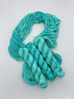 Turquoise skein of yarn on a light gray background